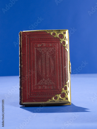 Gold bound red book on blue background