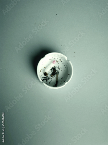 Used cigarette with lipstick mark in ashtray