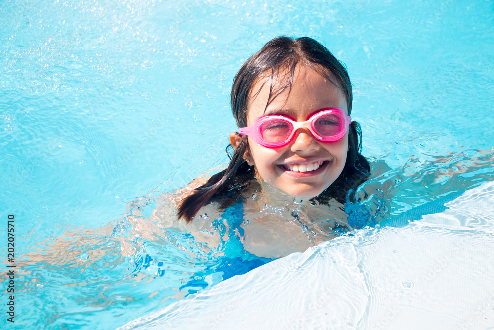 Funny little girl swimming in the pool