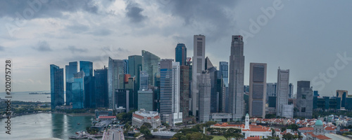 Aerial drone view of Singapore skyscrapers with city skyline during cloudy summer day