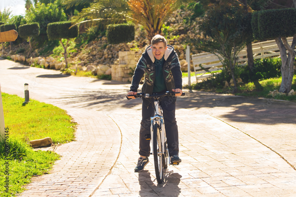 Handsome young man with bicycle in park on sunny day Handsome young man with bicycle in park on sunny day