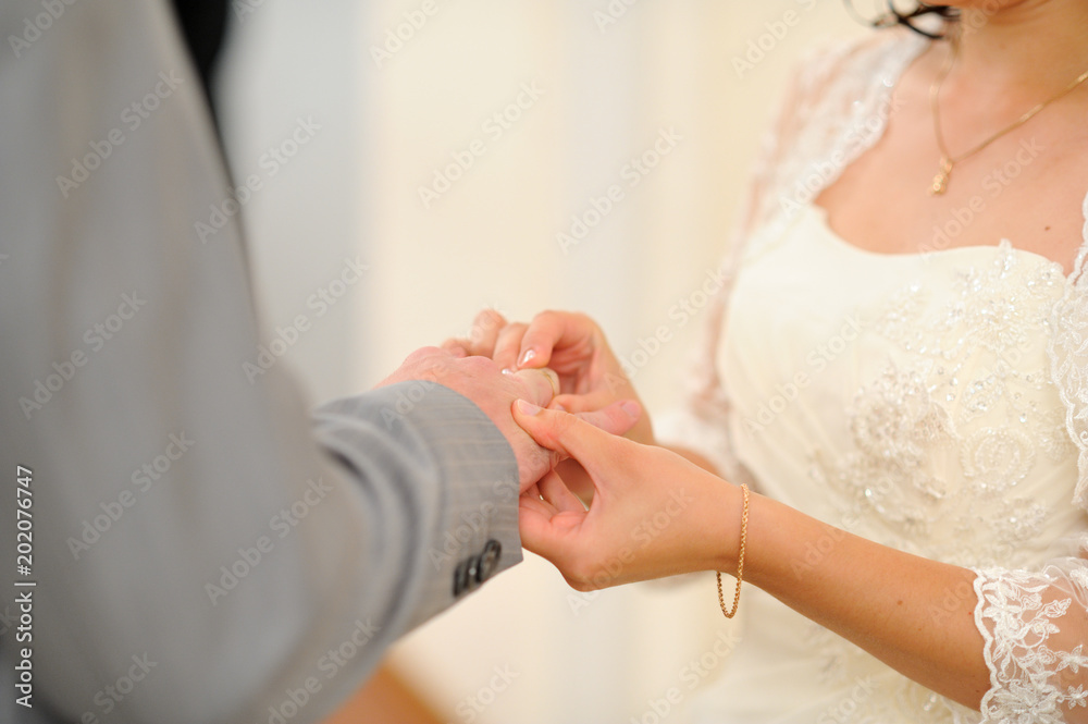 The bride puts on a wedding engagement ring. Wedding day. The bride puts on a wedding engagement ring. Wedding day.