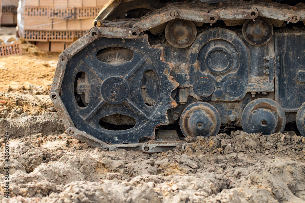 Tracked excavator work construction road .Close up of steel wheels crawler cranes, backhoes tracks