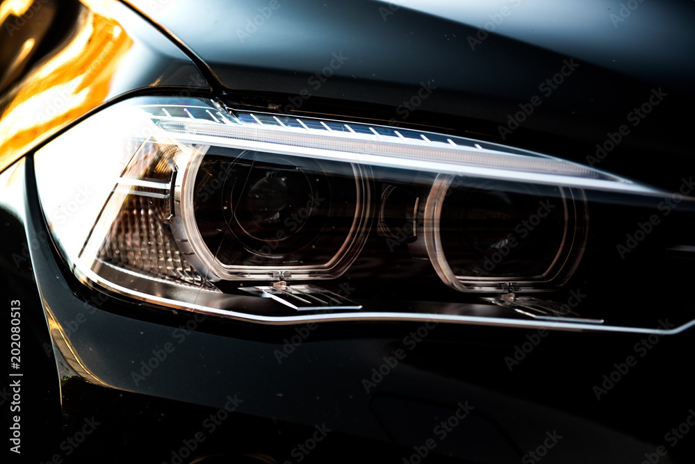 luxury black car head lamp. sunlight