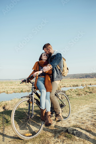couple in love on a bike on nature in autumn