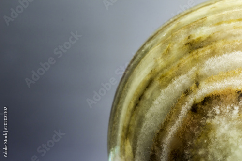 Fototapeta Naklejka Na Ścianę i Meble -  Macro photo texture of polished onyx stone on a gray background. Photo for the site about geology, stones, jewelry, handwork, textures,art, astronomy.