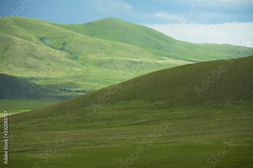 green hills under blue sky