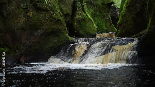 full view of the waterfalls cascading through the devils pulpit gorge in scotland