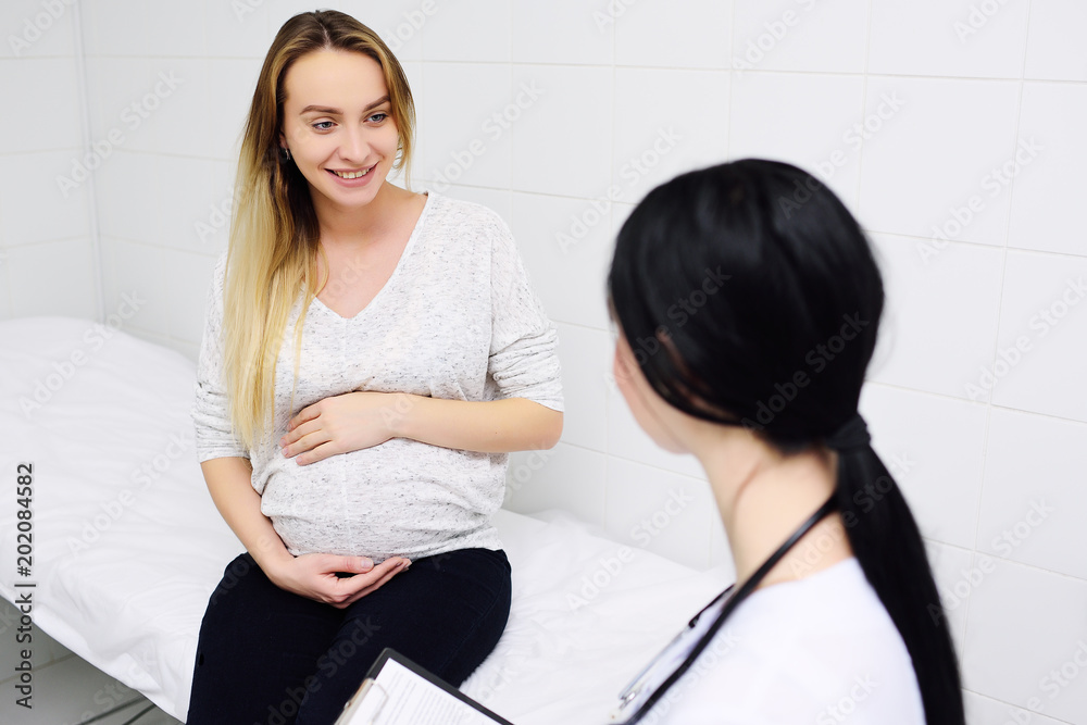 Fototapeta premium young pretty pregnant woman in a clinic at a female consultation with a gynecologist-obstetrician doctor