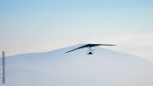 Fotografie Hang glider flying in the mountains