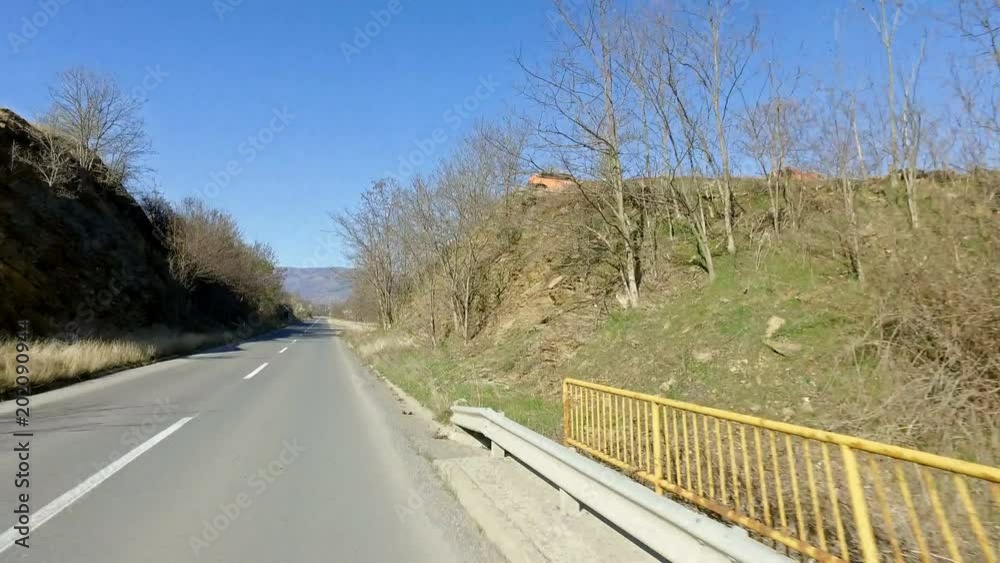 Driving pov on rural road over yellow fenced bridge Driving pov on rural road over yellow fenced bridge