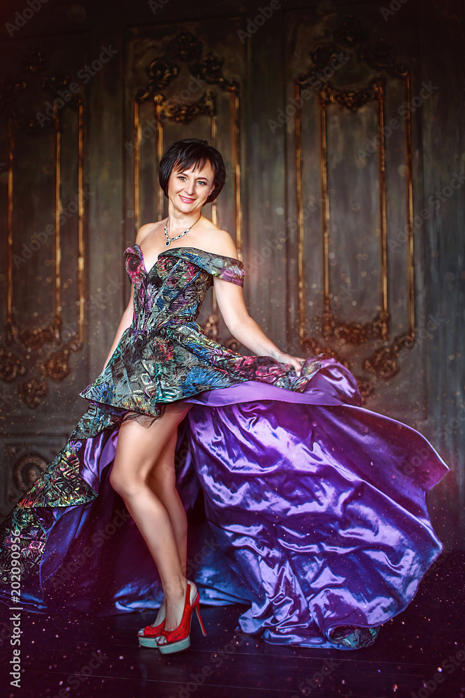 Charming woman in luxurious purple dress and red shoes