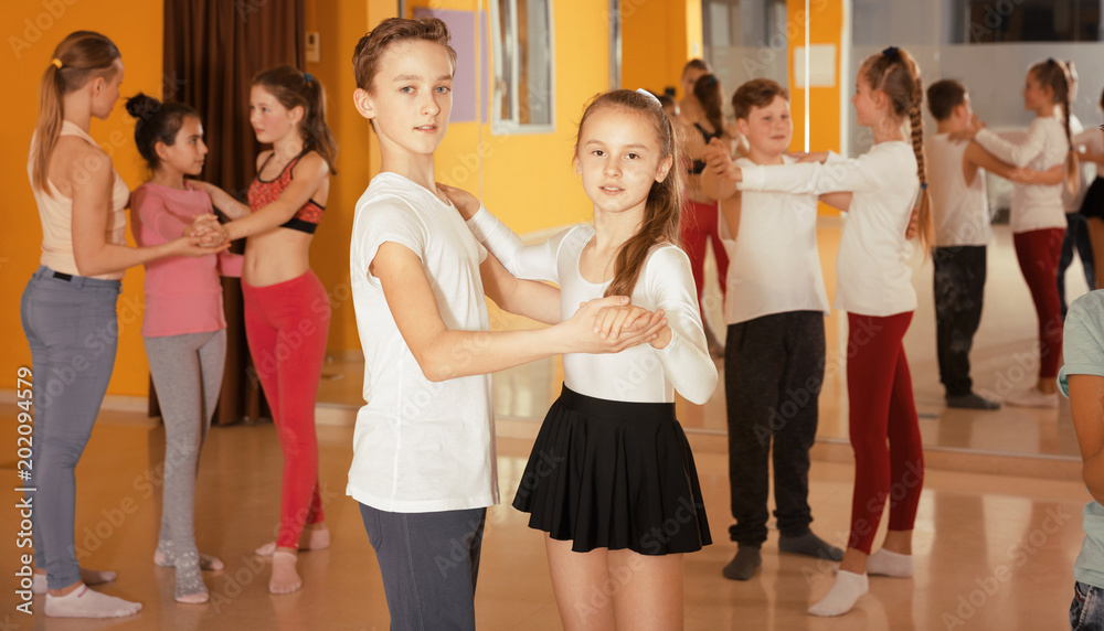 Teenagers dancing waltz in pairs in studio
