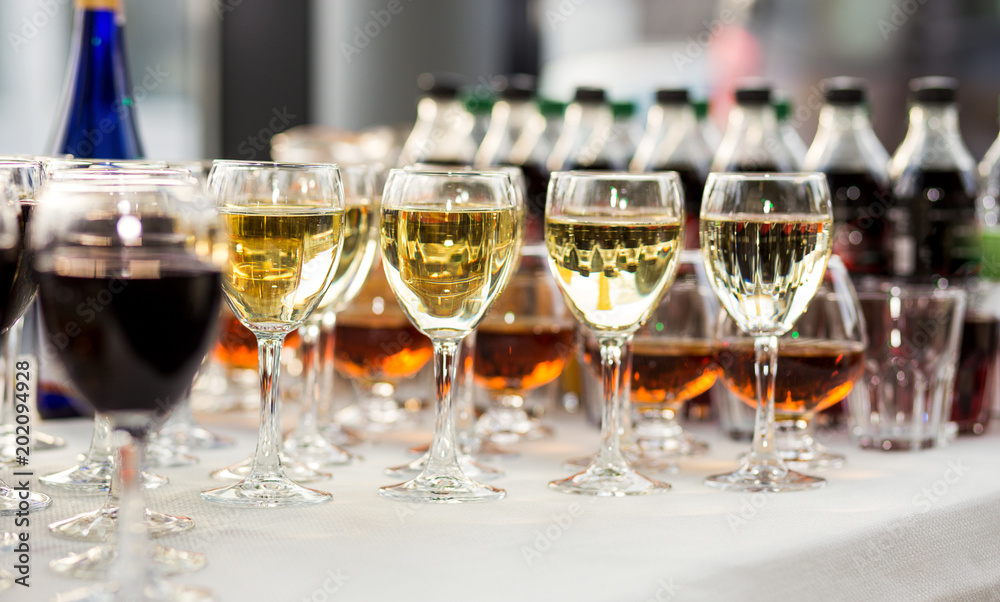 out catering, glasses with white and red wine, champagne, whiskey, juice and mineral water are on  table for the guests of  event