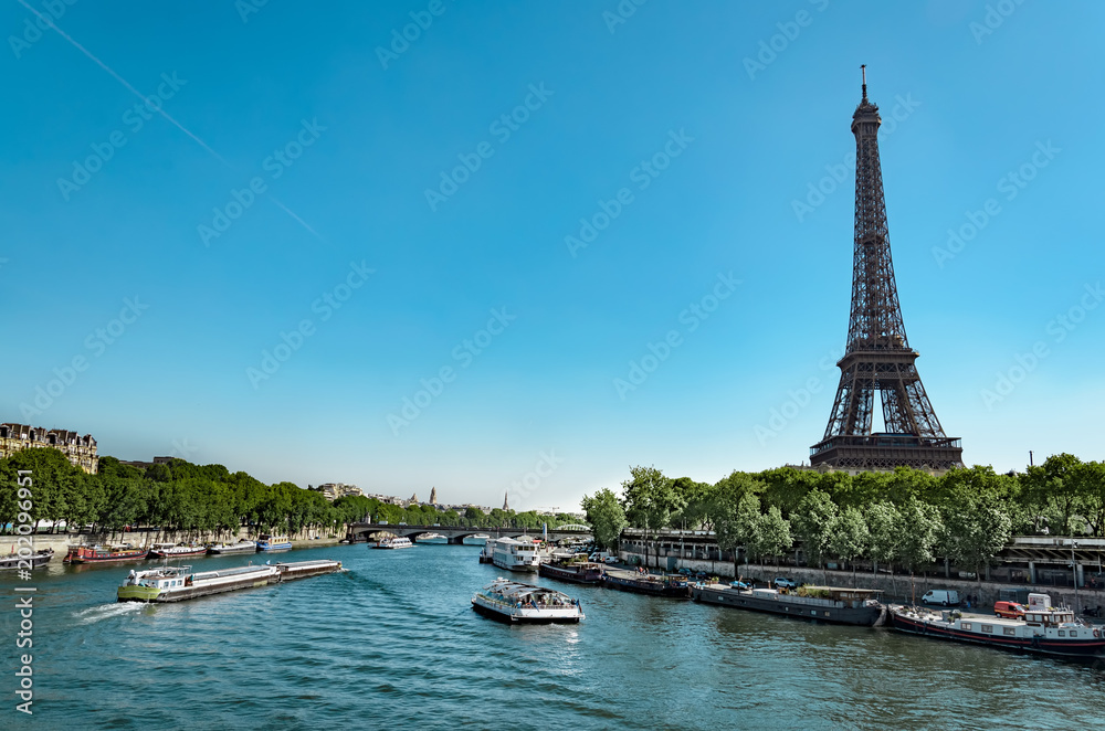 Panoramic view of living barge on the Seine in Paris with Eiffel tower and tourist and cargo boats, France