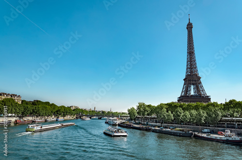 Panoramic view of living barge on the Seine in Paris with Eiffel tower and tourist and cargo boats, France © zefart