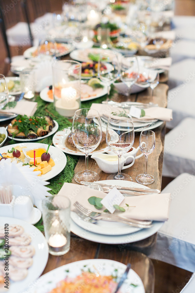 Fototapeta premium feast, dining, food concept. there is table that is waiting guests, it is almost prepared for celebrating, covered with tasty dishes, souces, snacks, but glasses are still empty
