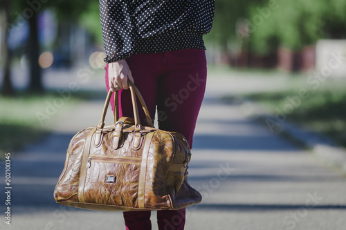 Woman holds a vintage leather travel bag photo