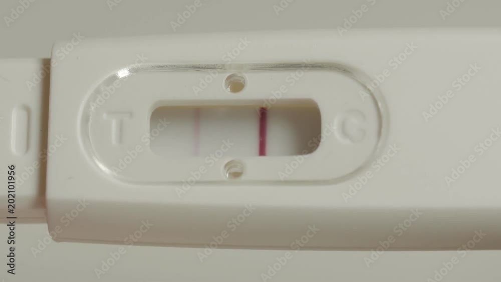 Positive pregnancy test in hands. Extremely close up shot. Positive pregnancy test in hands. Extremely close up shot.