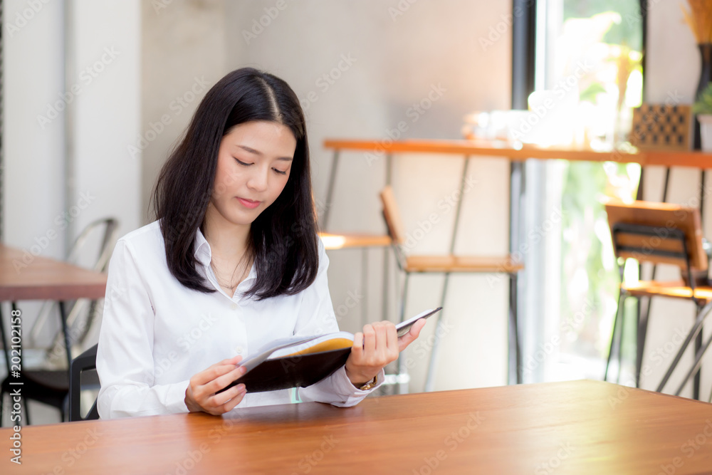 Beautiful business asian young woman reading on notebook on table, girl work at coffee shop, freelance businesswoman concept. Beautiful business asian young woman reading on notebook on table, girl work at coffee shop, freelance businesswoman concept.