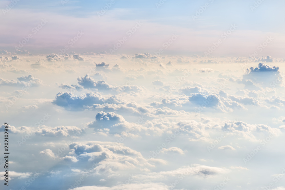 Evening sky over fluffy curly clouds. View from airplane. Beautiful skyline background. Soft focus Evening sky over fluffy curly clouds. View from airplane. Beautiful skyline background. Soft focus