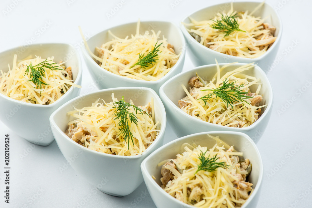 salad cheese, mushrooms, chicken, meat, dill, sauce in white plate on white background