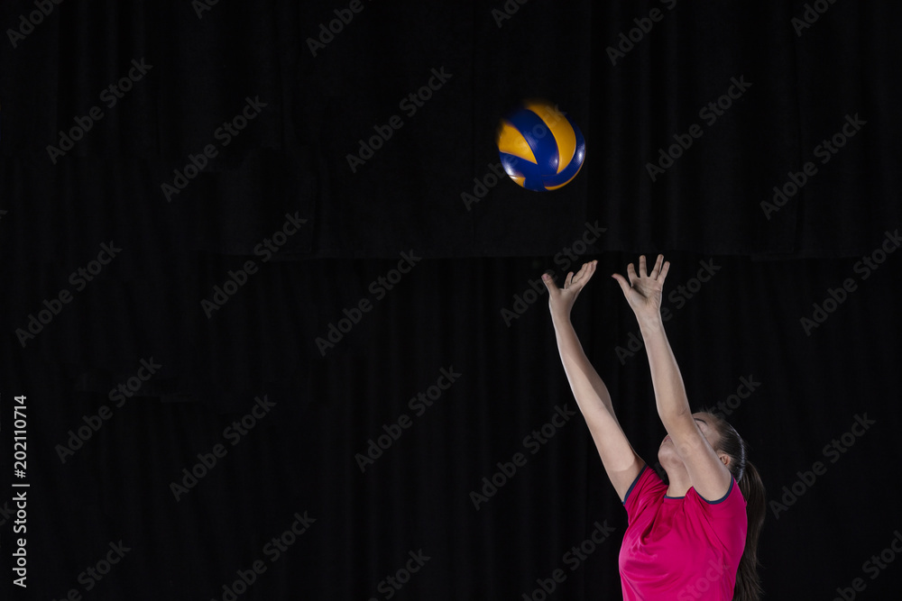 Young woman volleyball player isolated on black background