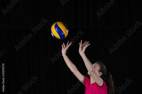 Young woman volleyball player isolated on black background