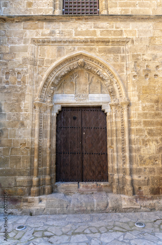 The old wooden door in the ornate stone wall of the church