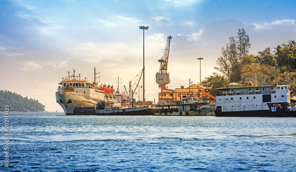 Port Blair harbor  at Andaman with view of ships and dockyard crane at sunset.