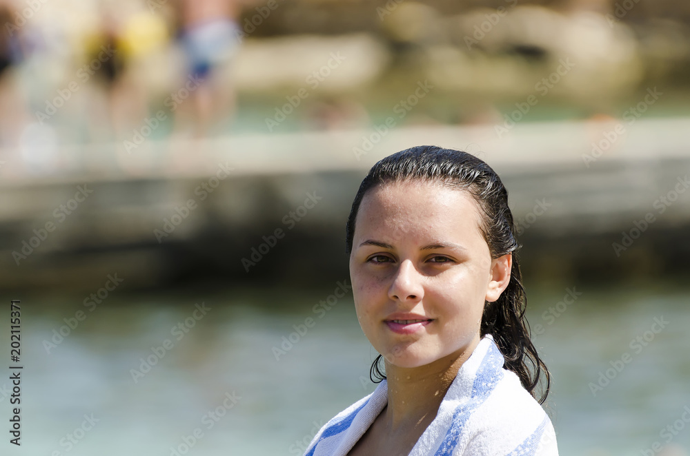 Portrait of happy girl smiling on the beach wrapped in a towel Portrait of happy girl smiling on the beach wrapped in a towel