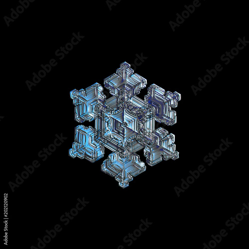 Snowflake isolated on black background. Macro photo of real snow crystal: elegant star plate with glossy relief surface, fine hexagonal symmetry, short, broad arms and complex pattern inside.