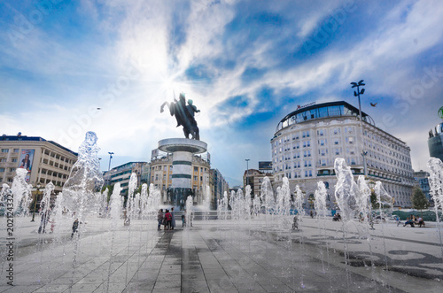 SKOPJE, MACEDONIA - NOVEMBER 26 2016: Day view of the macedonia square dominated by statue of alexander the great in skopje and dancing fountains backlit by the sun photo