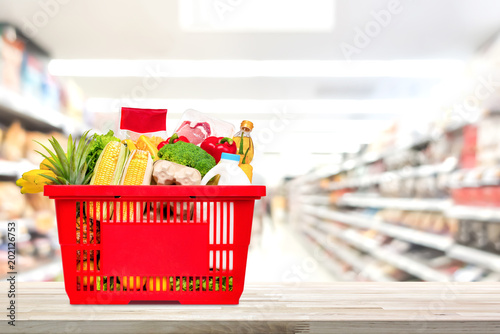 Shopping basket full of food and groceries on the table in supermarket