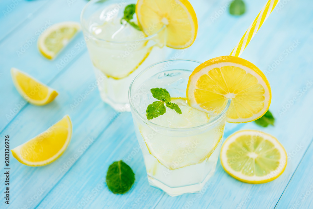 Refreshing drinks for summer, cold  lemonade juice with sliced fresh lemons - obrazy, fototapety, plakaty 