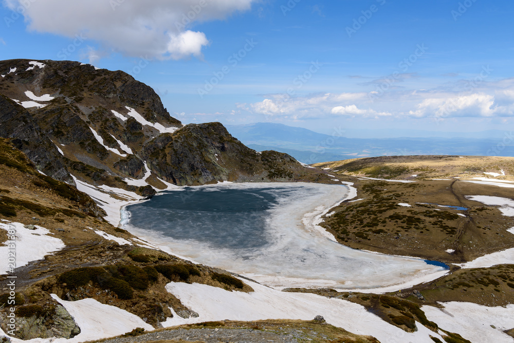 High angle view to the frozen waters of Bubreka or Babreka lake (kidney shaped lake) - one of the popular Seven Rila Lakes, Rila mountains, Bulgaria
