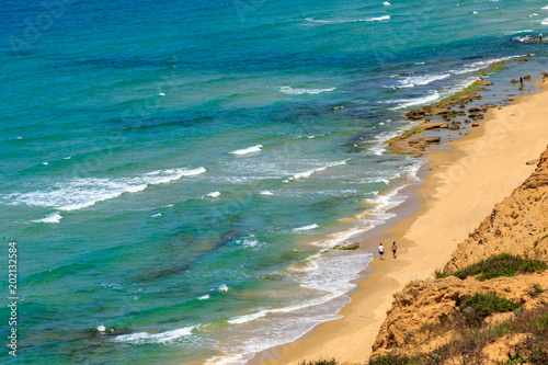 Panoramic view of sea beach with waves in sunny day.