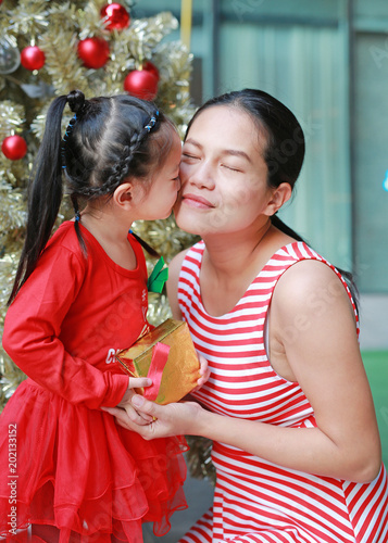 Happy little girl and mother with gift in Merry Christmas and Happy New Year times.
