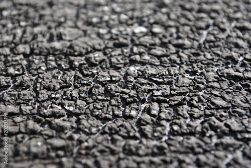 Dark surface cracked texture, soft blurry horizontal background, close up detail