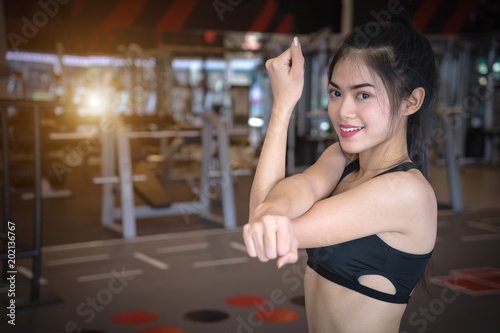 Asian woman exercising in gym. Young sports girl stretching exercises at fitness.