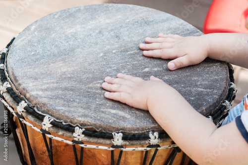 closeup of baby hands on african drums in outdoor
