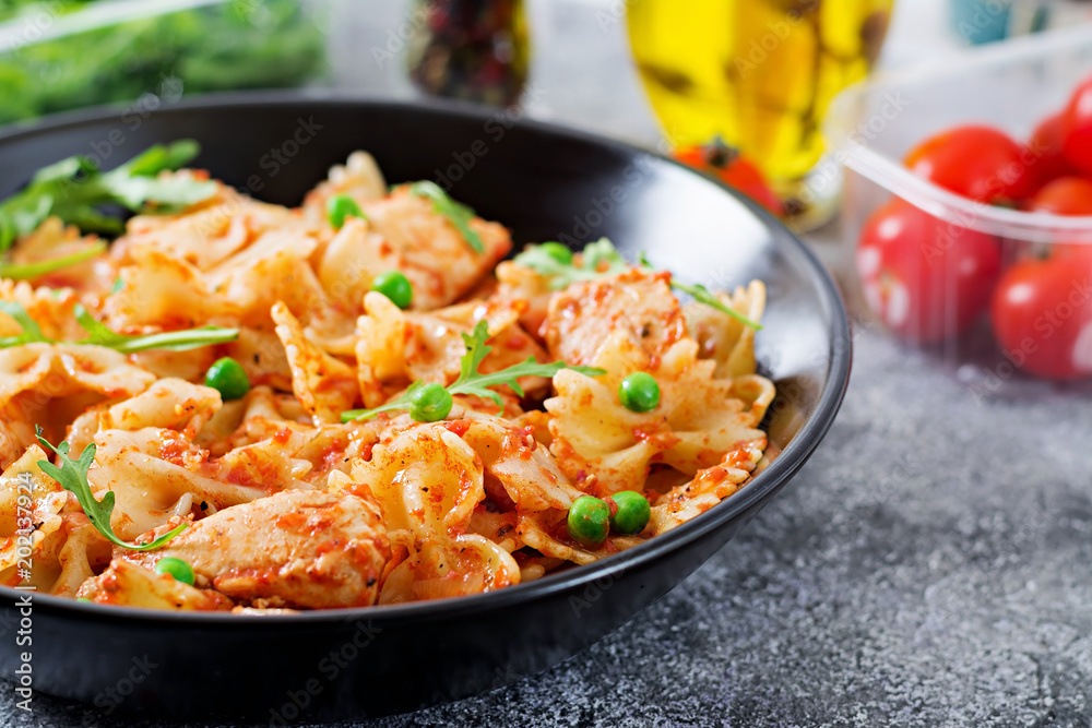 Farfalle pasta with chicken fillet, tomato sauce and green peas. Tasty food. Italian meal. Food menu Farfalle pasta with chicken fillet, tomato sauce and green peas. Tasty food. Italian meal. Food menu