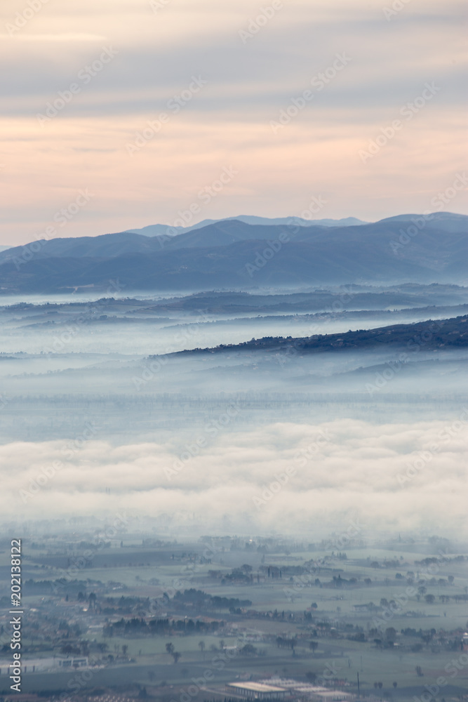Obraz premium Beautiful aerial view of Umbria valley in a winter morning, with fog covering trees and houses