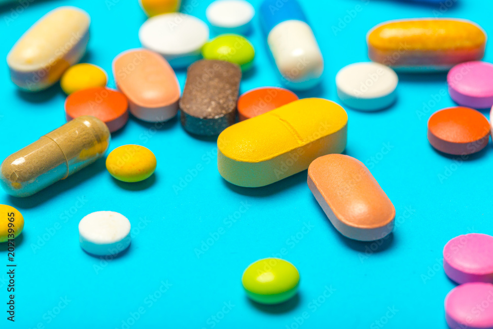 Pills are scattered over a blue background Pills are scattered over a blue background