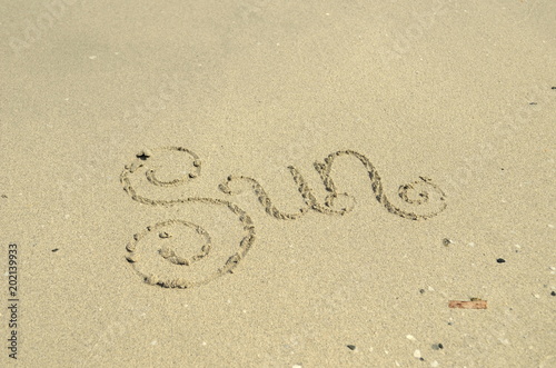 Sun hand lettered in sand on beach © treenabeena