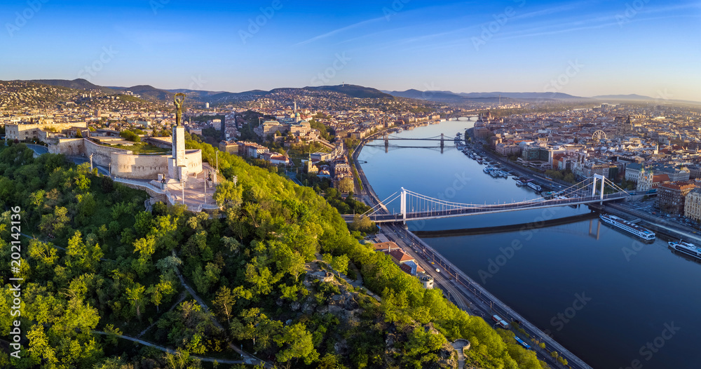 Budapest, Hungary - Aerial panoramic skyline view of Budapest at sunrise. This view includes the Statue of Liberty, Elisabeth Bridge, Buda Castle Royal Palace and Szechenyi Chain Bridge with blue sky