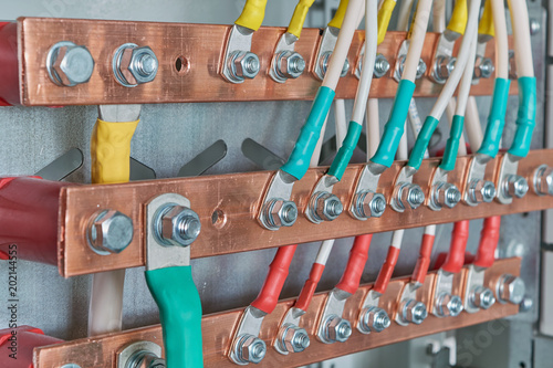 Electric bus bars connected to it by wires or cables. The cables are connected with cable lugs and nuts bolts. Accumulation and interlacing of wires or cables in the electrical Cabinet.