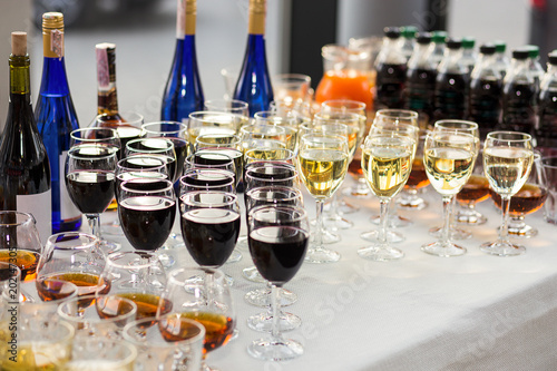 out catering, glasses with white and red wine, champagne, whiskey, juice and mineral water are on  table for the guests of  event