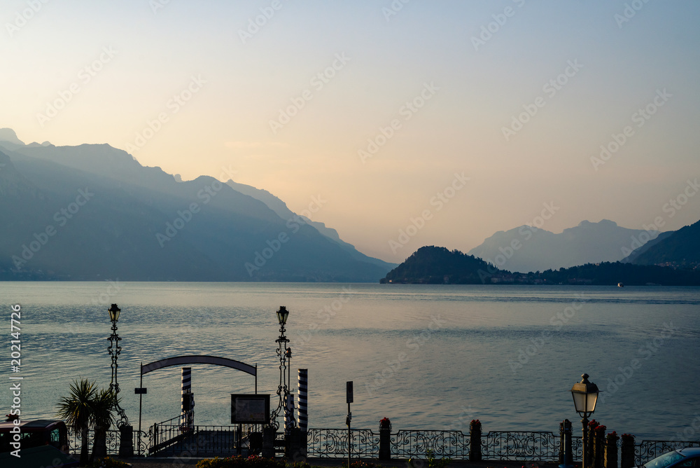 Sunrise on the mountains of the Lake of Come over calm water, from Menaggio in Italy