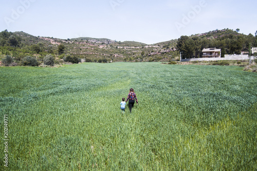 Mother and son in a huge green field